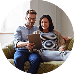 Couple lounging on sofa with tablet