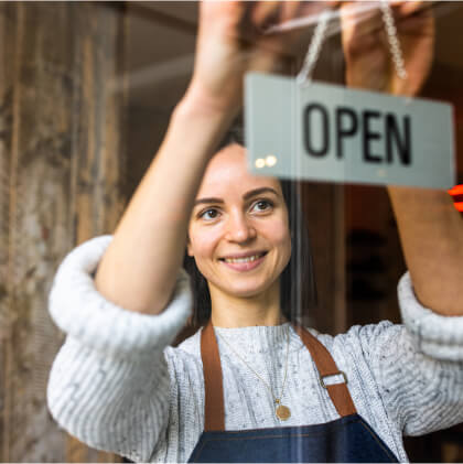 happy businesswoman with "open" sign