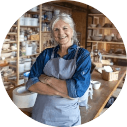 a female proudly stands in her pottery shop